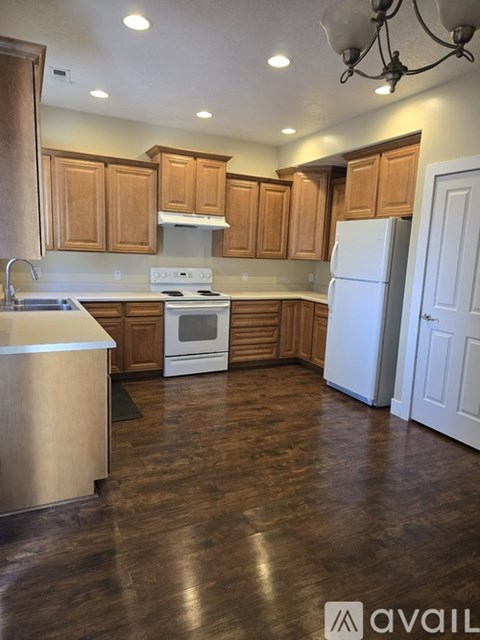 A kitchen with wooden cabinets and a white stove top oven.