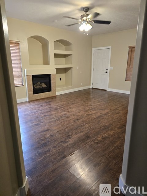 A living room with a fireplace and wood flooring.