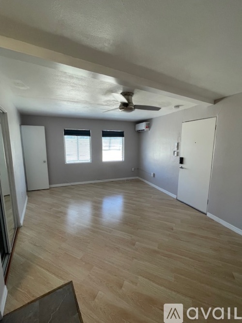 A room with wooden flooring and a ceiling fan.