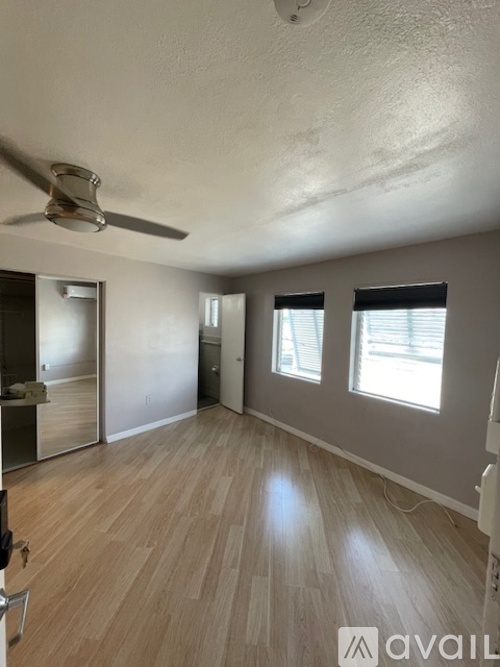 A room with a ceiling fan and wooden flooring.