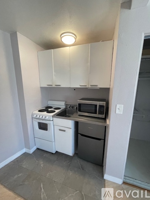 A kitchen with white appliances and cabinets.