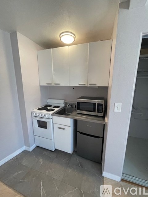 A kitchen with white appliances and cabinets.