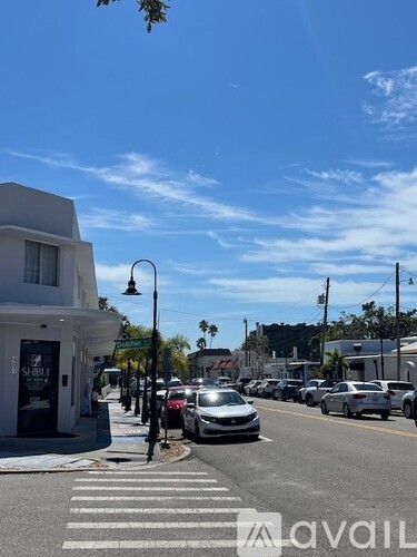 A street view with cars and a building on the left.