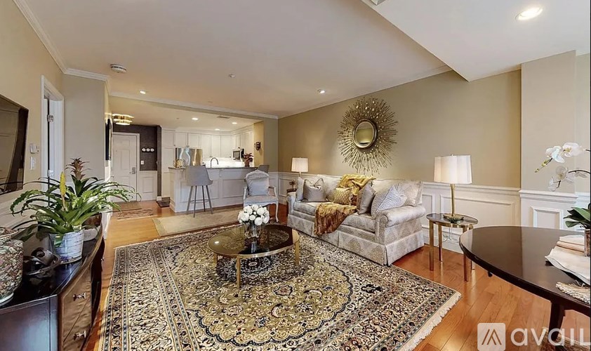 A living room with a rug, a sofa, a coffee table, and a mirror on the wall.