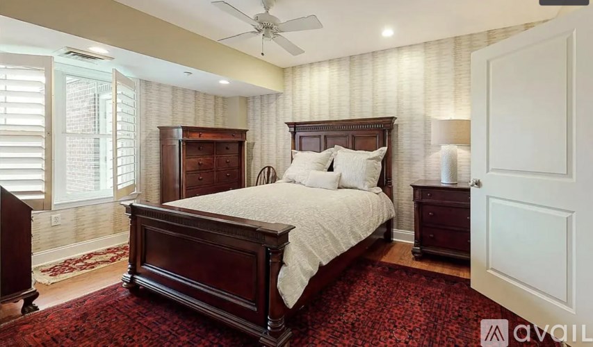 A bedroom with a large bed and a ceiling fan.