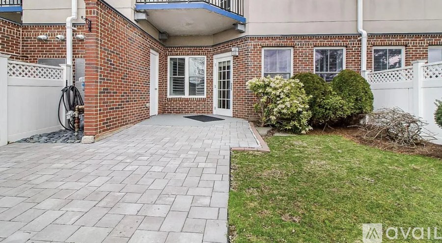 A brick house with a white fence and a small garden in front.