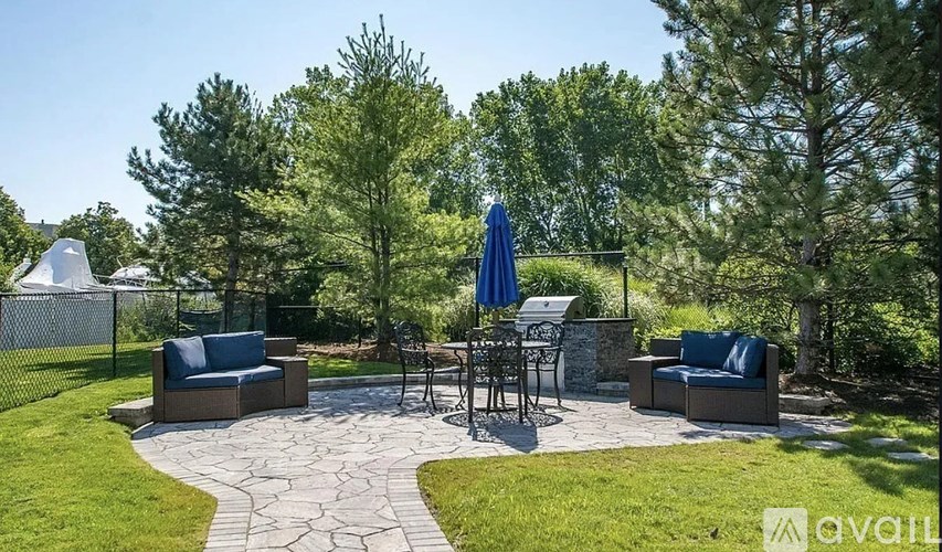 A patio with a table and chairs surrounded by trees.