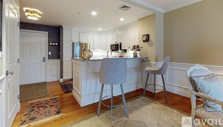 A kitchen with a bar stool and a chair.