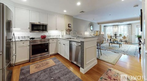 A modern kitchen with white cabinets and stainless steel appliances.