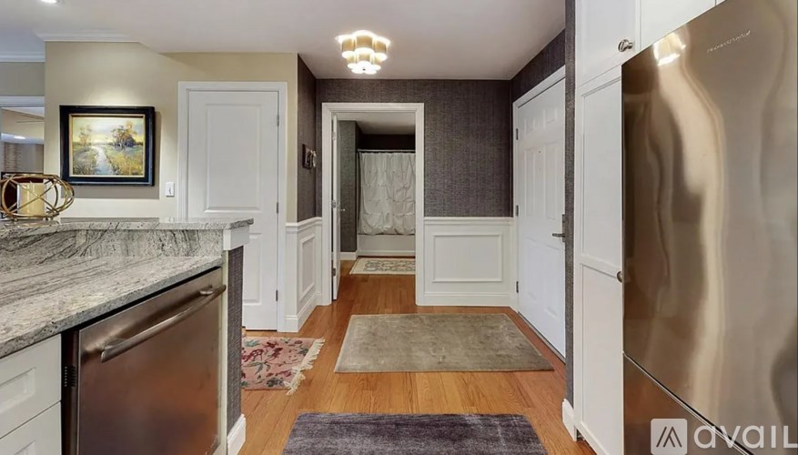 A kitchen with a refrigerator on the right and a dining area with a table and chairs in the background.