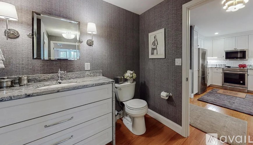 A bathroom with a toilet, sink, and mirror.