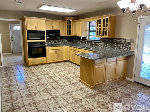 A kitchen with wooden cabinets and a granite countertop.