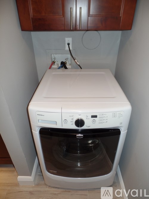 A white front loading washing machine with a white sink built into the top.