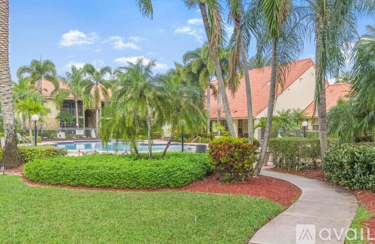 A house with a pool surrounded by palm trees.
