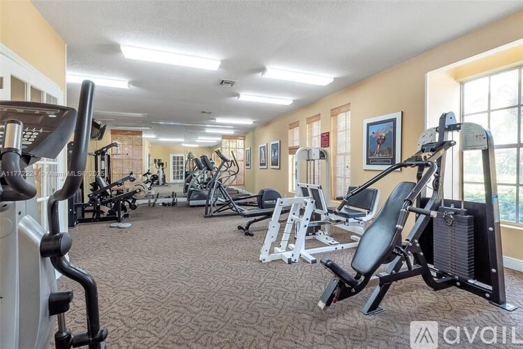 A gym with a variety of equipment including treadmills, weights, and exercise machines.