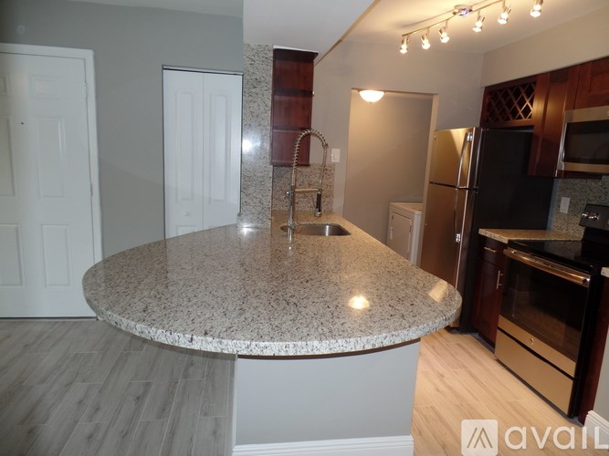 A kitchen with granite countertops and wooden cabinets.