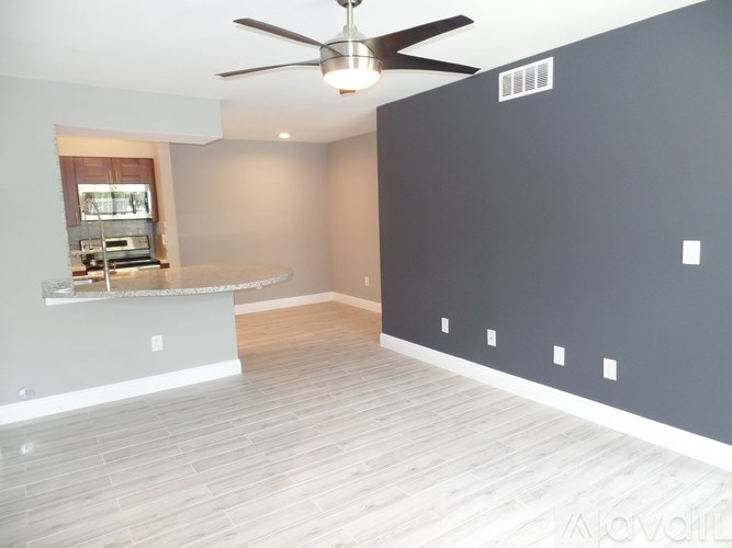 A spacious room with a ceiling fan and a countertop.