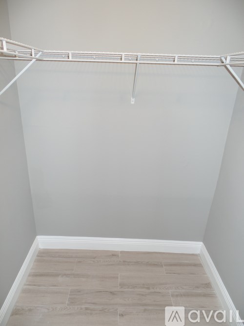 A white clothes drying rack is on the wall.