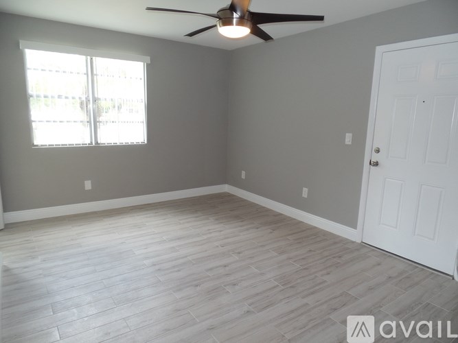A room with a ceiling fan and a door.