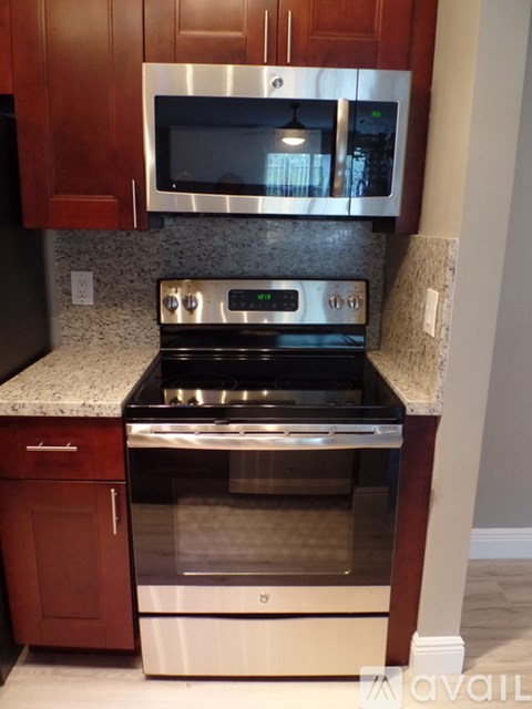 A kitchen with a stove top oven and microwave above it.
