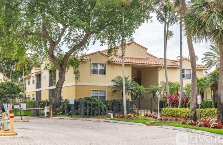 A yellow building with a black fence in front of it.