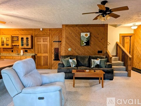 A living room with a white chair and a couch.