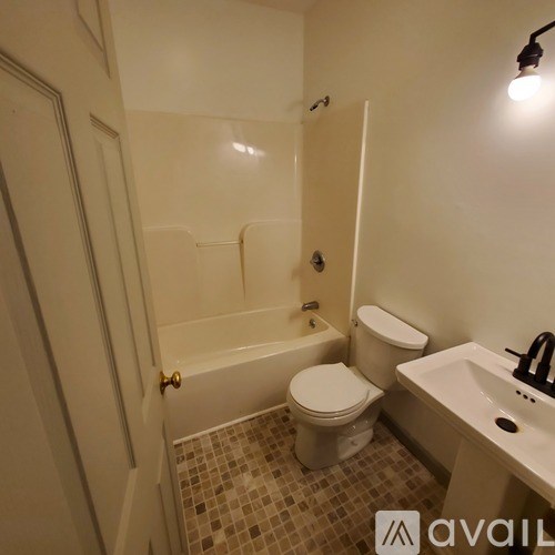 A bathroom with a toilet, sink, and bathtub.