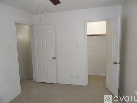A room with two white doors and a ceiling fan.