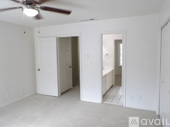 A room with a ceiling fan and a carpeted floor.