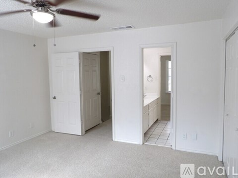 A room with a ceiling fan and a carpeted floor.