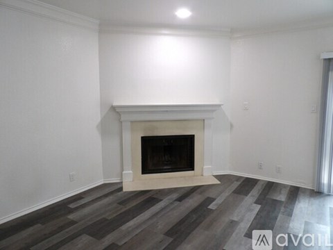 A kitchen with a white fridge and a window with blinds.