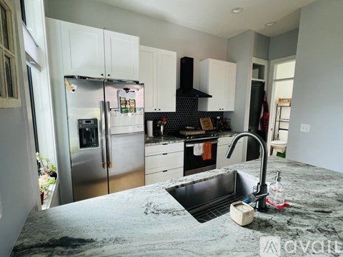 A kitchen with a granite countertop and stainless steel appliances.