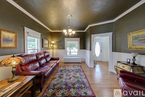 A living room with a red couch and a wooden coffee table.
