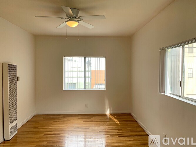 A room with a ceiling fan and wooden flooring.