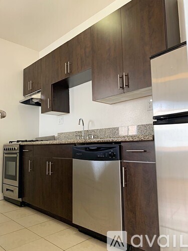 A kitchen with brown cabinets and stainless steel appliances.