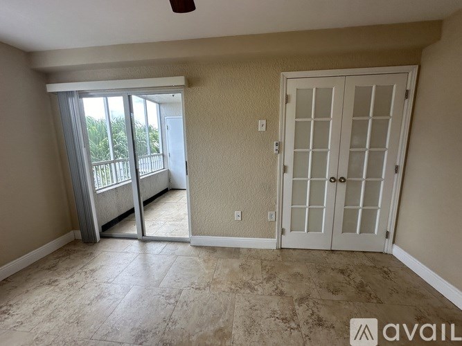 A room with a sliding glass door leading to a balcony.