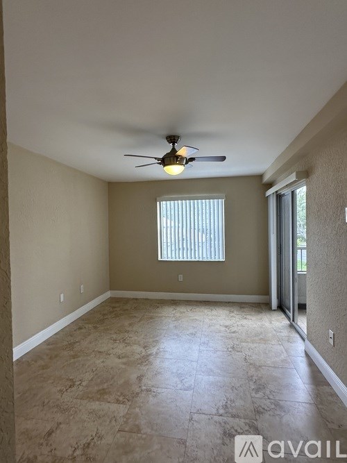 A room with a ceiling fan and a window with blinds.