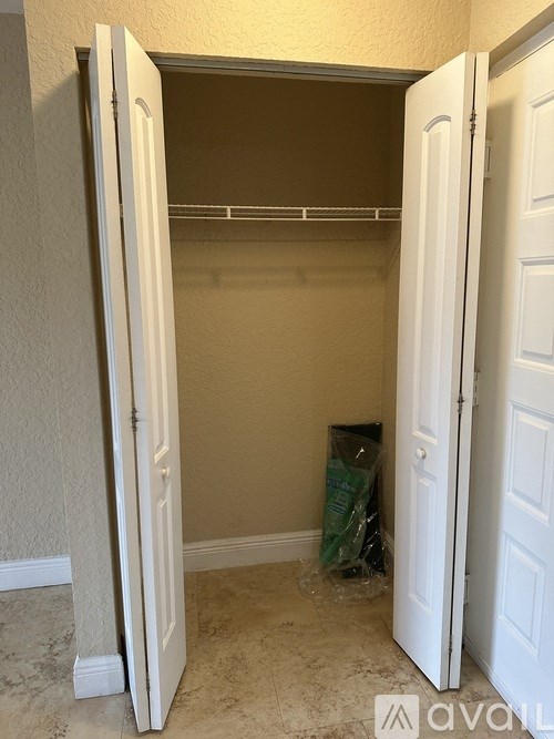 A white door is open to a room with a bag on the floor.