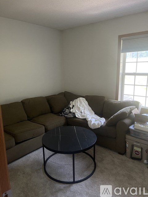 A living room with a brown couch and a black coffee table.