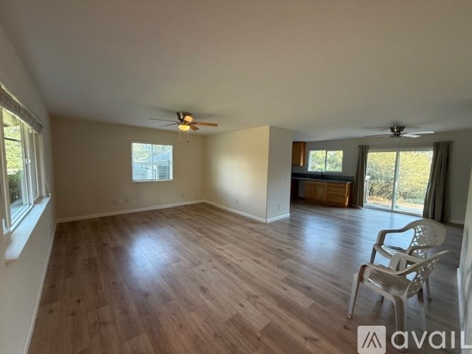 A room with wooden flooring and a ceiling fan.