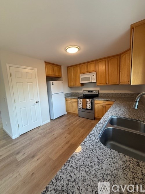 A kitchen with wooden cabinets and a white fridge.