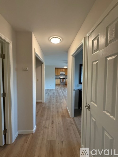 A long hallway with doors on both sides and a light on the ceiling.