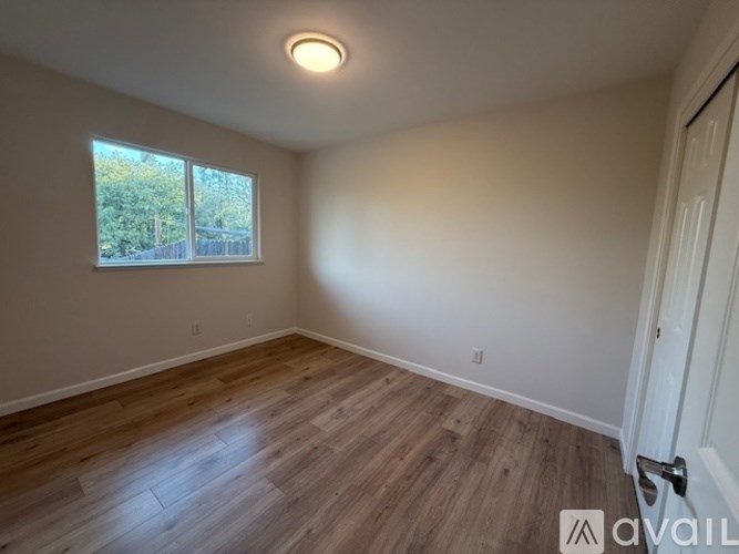 A room with wooden flooring and a window.