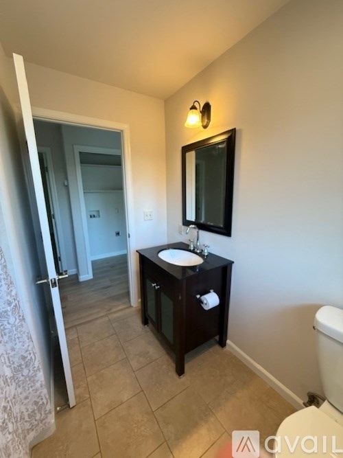 A bathroom with a sink, mirror, and toilet.