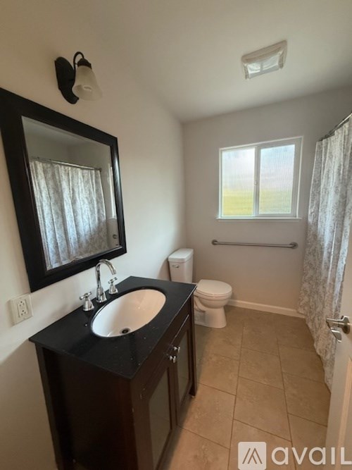 A bathroom with a sink, mirror, toilet and bathtub.