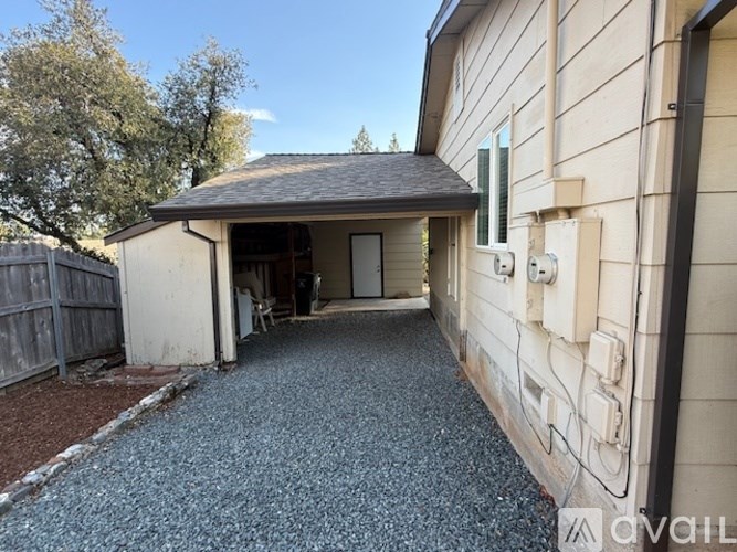 A house with a gravel driveway leading to a garage.