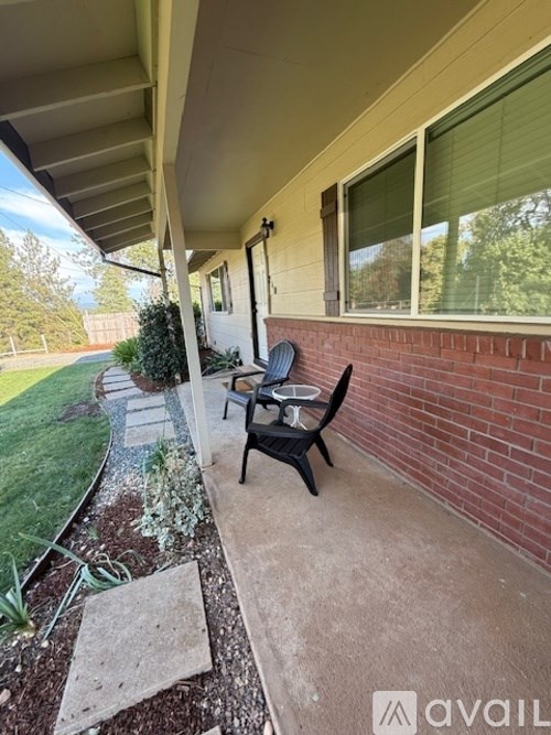 A patio with a black chair and a table is shown.