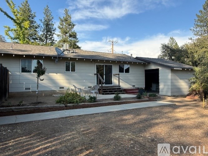 A house with a driveway and trees in the background.