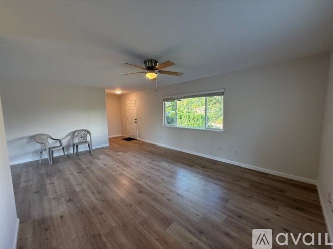 A room with wooden flooring and a ceiling fan.