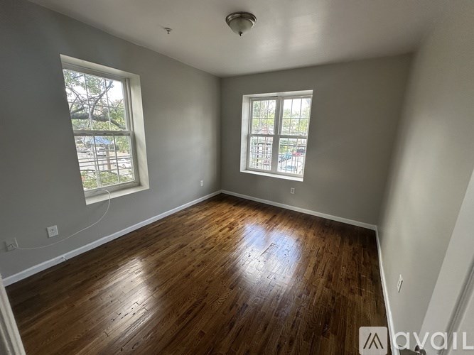 A room with wooden floors and two windows.